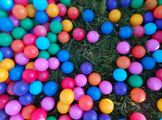 Multicolored balls randomly scattered on the grass