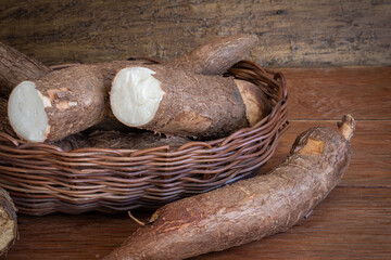 Fresh Cassava root on a wooden background. Copy space.