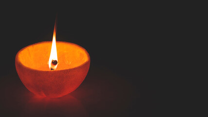 burning candle on black background