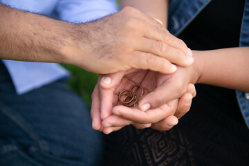 couple holding their wedding rings in their hands
