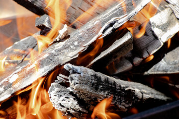 Burning firewood and coals in the grill. Close-up. Macro shooting. Burning fire. Grilling meat. Coals for frying