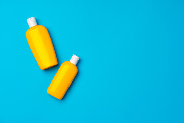 Bottles of sunscreen cream on blue background