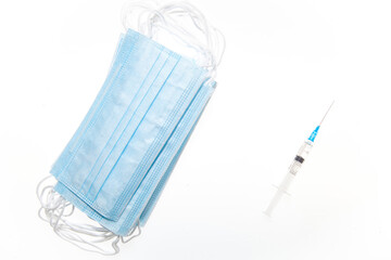 Medical mask and syringe isolated on a white background