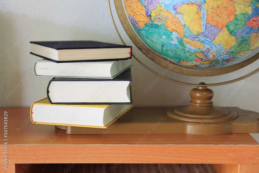 Wall mural close-up of several books stacked on the bookshelf in the library selective focus and shallow depth 