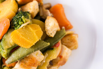 Stir fry chicken with vegetables on wooden table.Close up