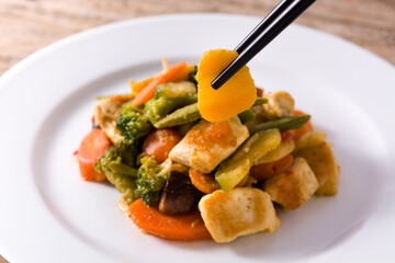 Stir fry chicken with vegetables on wooden table