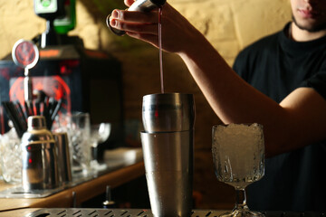 Fototapeta na wymiar Bartender preparing fresh alcoholic cocktail at bar counter, closeup