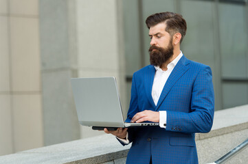 hard working day. good internet connection. confident businessman hold notebook. bearded businessman reply to e-mail. formal man in office suit distant working. digital technology in modern life