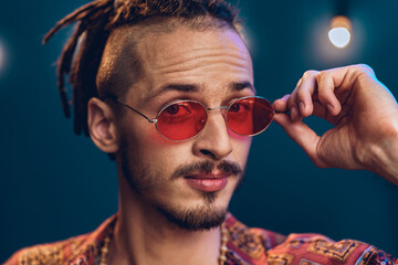 Stylish guy with dreadlocks wearing pink sunglasses