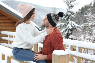 Happy couple in warm sweaters outdoors on winter day