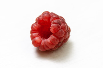 Ripe raspberry isolated on white background close-up. Fresh raspberries without sheets on the table. Macro shooting.