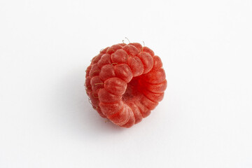 Ripe raspberry isolated on white background close-up. Fresh raspberries without sheets on the table. Macro shooting. Healthy, wholesome food.