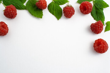 Many ripe raspberries isolated on white background close-up. Beautiful red fresh raspberries with leaves along the contour on the table. Top view. Banner for web site. Free space for text