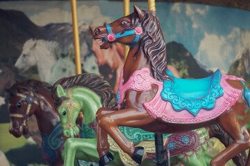 Fototapeta na wymiar Close up of Carousel that has no customers to play. Colorful three horses in merry-go-round ready to play at amusement park
