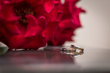 Wedding rings and a bouquet of red roses