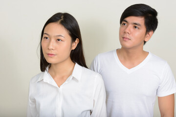 Portrait of young Asian couple together against white background