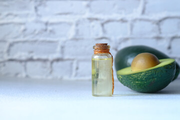 Top view of oil and slice of avocado on wooden table 