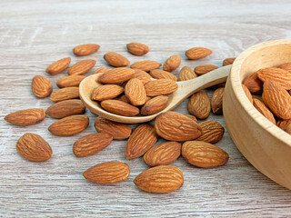almonds on wooden table, almond on wooden spoon.