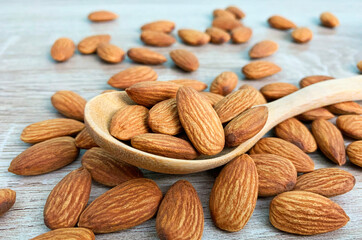 almonds on wooden table, almond on wooden spoon.