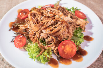 Freshly cooked delicious ripped pork on a wooden tray