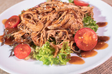 Freshly cooked delicious ripped pork on a wooden tray