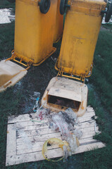 Fototapeta na wymiar Yellow garbage bins on the park. Out of order