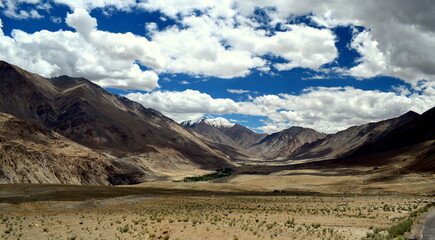 Rugged Mountain valley in a cold desert setting in ladakh with a few snow clad peaks in the background - obrazy, fototapety, plakaty