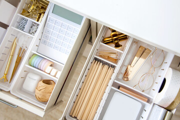 Female white workplace. A method for storing stationery neatly. Stylish gold pens, stapler,...