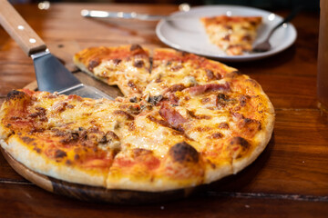 Close up pizza on woodden plate.