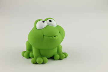 green rubber bath toy frog side facing with big eyes, isolated on a white background