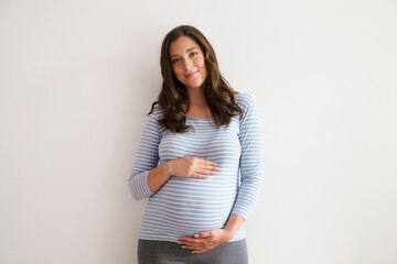 Portrait shot of young beautiful woman on third trimester of pregnancy. Close up of pregnant female...