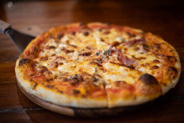 Close up pizza on woodden plate.