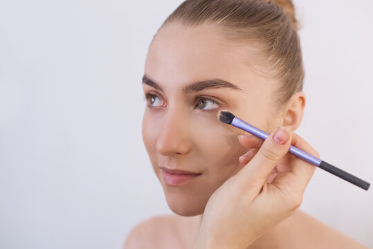 A Beautiful Girl With No Makeup, Who Is Applied A Foundation With A Brush. Close-up Portrait Of A Model Not Looking At The Camera. Clean Well-groomed Face, Fresh Skin, Care And Maintenance. Copy Space