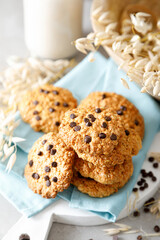 Fototapeta na wymiar Homemade oatmeal cookies with chocolate drops and milk for breakfast.