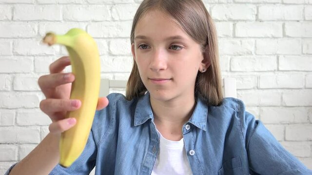 Kid Eating Banana, Child Eats Fruits, Young Girl at Breakfast in Kitchen