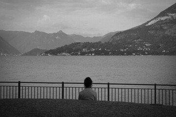 Admires the lake.
Black and white photo with lady in relax that admire the landscape lake.