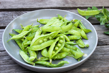 Young, green peas on a twig and on a Board close-up