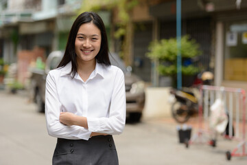 Portrait of young beautiful Asian businesswoman outdoors