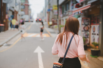 Obraz premium new normal traveling with solo woman traveler in shopping street at seoul korea