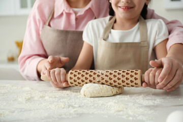 Mother and daughter cooking together in kitchen, closeup