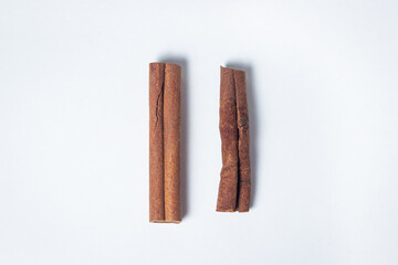 Cinnamon on a white background. Two cinnamon sticks, one next to the other. Photo from above