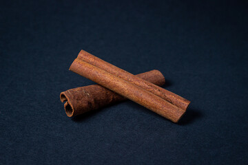 Cinnamon on a black background. Two cinnamon sticks, one on top of the other.
