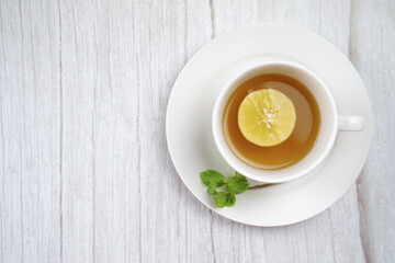 Top view of Cup of hot honey lemon tea and mint on wooden table. the concept of natural medicine.