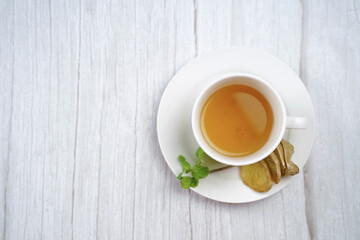 Top view of Cup of hot ginger tea with lemon and mint on wooden table. the concept of natural medicine.