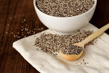 Chia seeds in a bowl with wooden spoon