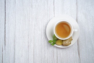 Top view of Cup of hot ginger tea with lemon and mint on wooden table. the concept of natural medicine.
