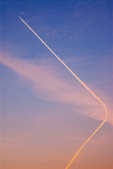 Fototapeta na wymiar Vertical image of high altitude plane white trails in a colourful sky