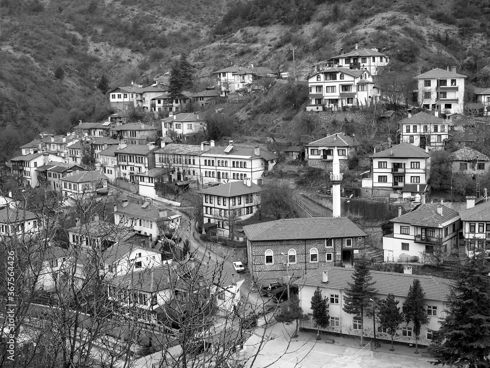 Sticker High angle greyscale shot of a small village on a hill