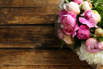 Bouquet of beautiful peonies on wooden table. Space for text