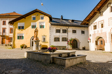 Naklejka premium Scuol, Dorf, Brunnen, Engadiner Dorf, Unterengadin, Engadiner Häuser, Dorfplatz, Alpen, Graubünden, Inn, Fluss, Sommer, Schweiz